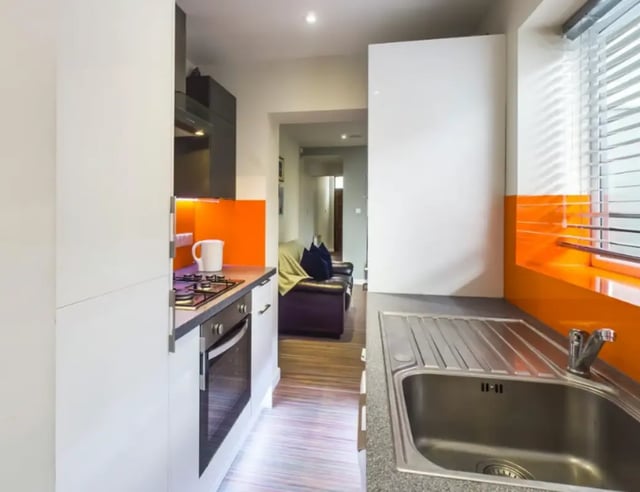 Modern kitchen with oven sink and orange accents kitchen at 23 Carlton Road in Stoke-On-Trent Student Accommodation