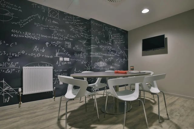 Chalkboard wall table chairs television study area at George Street Apartments in Glasgow Student Accommodation