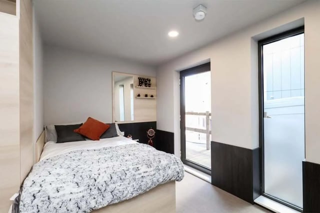Bed with patterned duvet orange pillow mirror bedroom at Steel City in Sheffield Student Accommodation