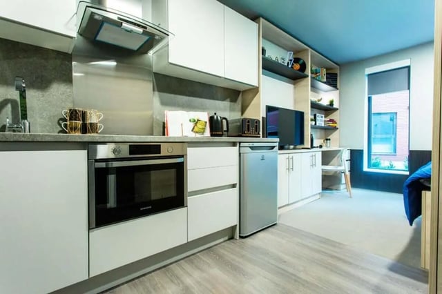 Modern kitchen area with integrated appliances and study space. at Steel City in Sheffield Student Accommodation