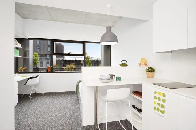 Desk chair bed kitchen bar stools and counter living room at Scape Carlton in Melbourne Student Accommodation
