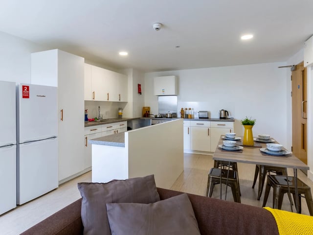 Modern kitchen with dining area and white cabinets Kitchen at The Lantern in Liverpool Student Accommodation
