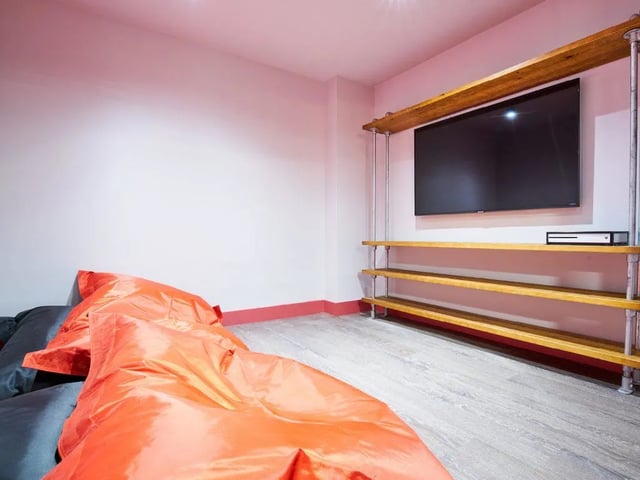 Orange beanbags and TV on shelves living room at The Lantern in Liverpool Student Accommodation