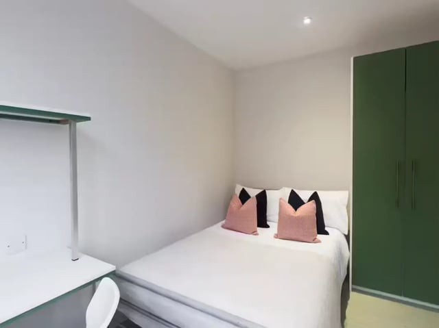 Bed with pink pillows and green wardrobe Bedroom at 85 Seaford Street in Stoke-On-Trent Student Accommodation