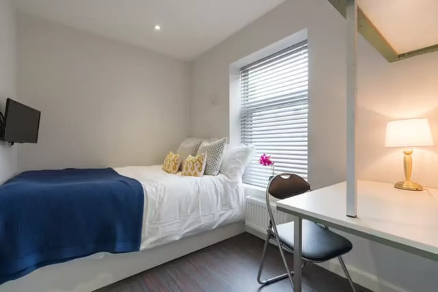 Bed TV pillows blue throw window desk lamp bedroom at 85 Seaford Street in Stoke-On-Trent Student Accommodation