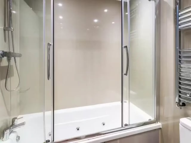 Shower over bathtub with glass doors and towel rail bathroom at 24 Seaford Street in Stoke-On-Trent Student Accommodation
