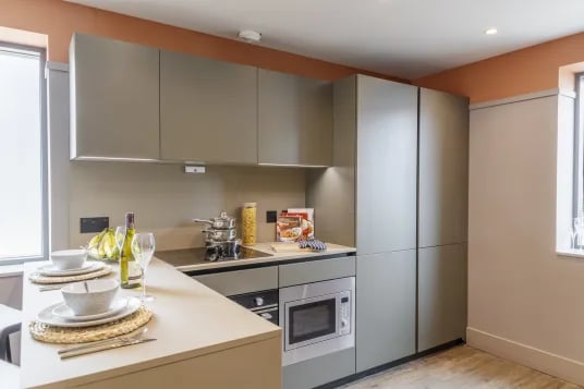 Modern kitchen with microwave and place settings kitchen at The Garage Egham in Egham Student Accommodation