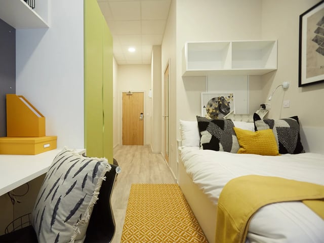Bed with yellow pillows and rug Bedroom at The Barn in Exeter Student Accommodation