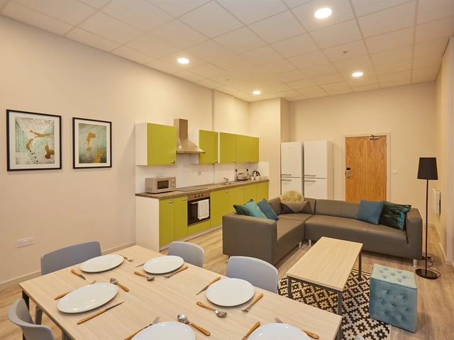 Dining table sectional sofa kitchen living room at The Barn in Exeter Student Accommodation