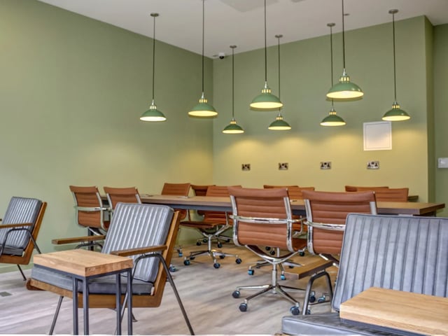 Chairs and tables in a communal lounge area at The Barn in Exeter Student Accommodation