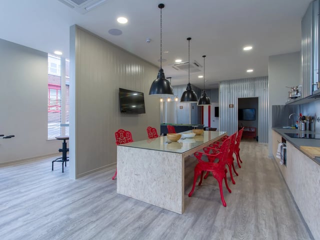 Dining table red chairs television pool table kitchen communal area at The Barn in Exeter Student Accommodation