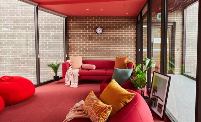Red sofa beanbags plants framed art living room at Scape Darlington in Sydney Student Accommodation