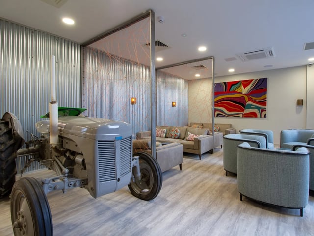 Tractor seating area with colorful abstract art living room at The Barn in Exeter Student Accommodation