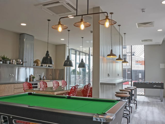 Pool table kitchen bar stools foosball game area at The Barn in Exeter Student Accommodation