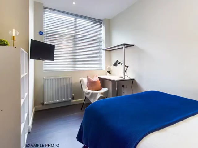 Bed with blue blanket desk chair and TV bedroom at 93 Thornton Road in Stoke-On-Trent Student Accommodation