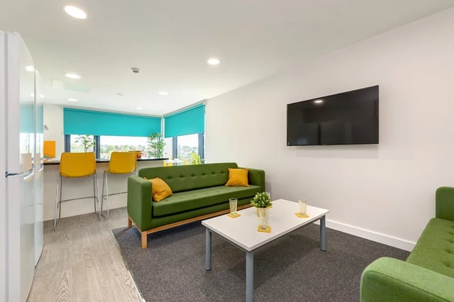 Green sofa coffee table television living room at Central Living in Exeter Student Accommodation