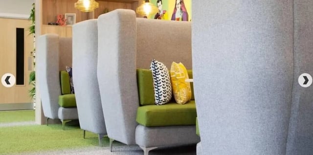 Booth seating with green cushions and patterned pillows communal area at Denmark Road in Manchester Student Accommodation