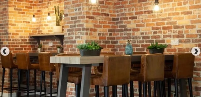 High table with brown bar stools common area at Denmark Road in Manchester Student Accommodation