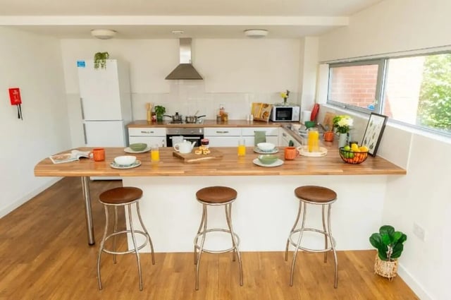 Breakfast bar with stools and kitchen appliances kitchen at Denmark Road in Manchester Student Accommodation