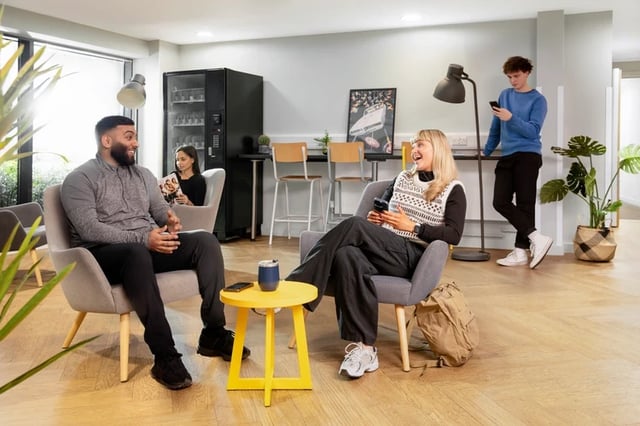 Students relaxing in armchairs near vending machine common area at Mary Sturge in Birmingham Student Accommodation