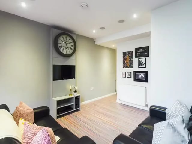 Modern living room with black sofas and artwork Living room at 30 Watford Street in Stoke-On-Trent Student Accommodation