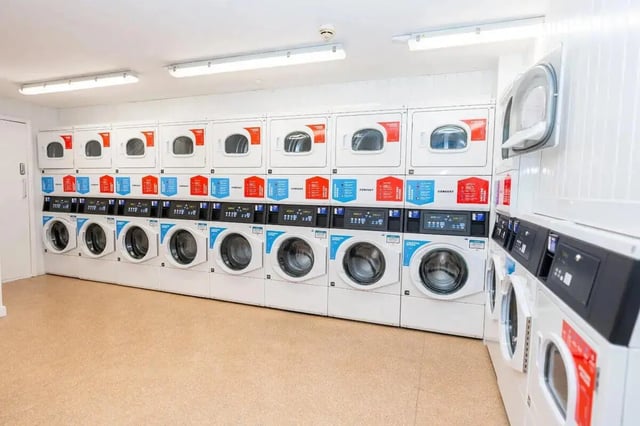 Rows of white washing machines laundry room at Grafton Street in Manchester Student Accommodation
