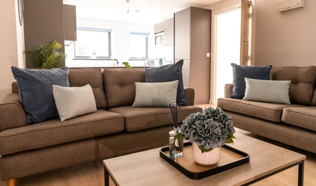 Brown sofas with blue and grey cushions living room at Boutique Student Living - Exeter in Exeter Student Accommodation