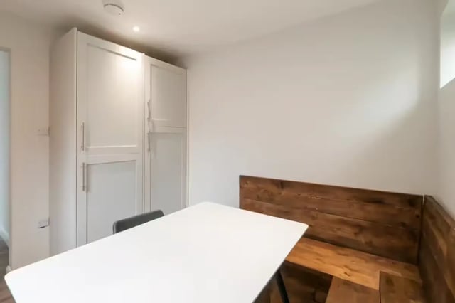 White table wooden bench storage cabinets dining area at 51 Beresford Street in Stoke-On-Trent Student Accommodation