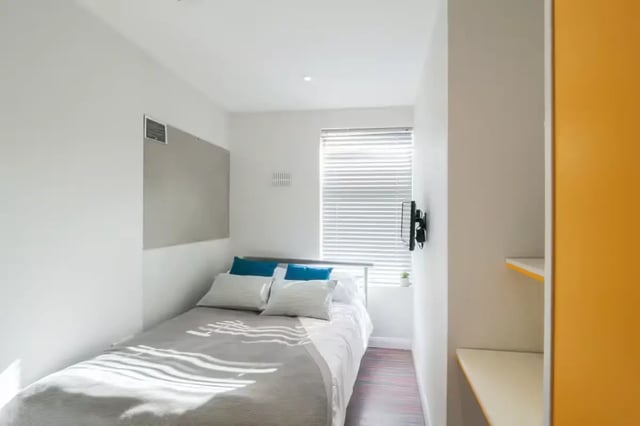 Bed with pillows whiteboard TV window shelves bedroom at 51 Beresford Street in Stoke-On-Trent Student Accommodation