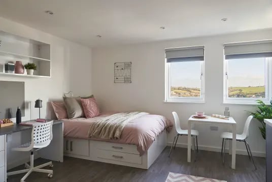Bed desk chairs and table in room Bedroom at The Quarry in Falmouth Student Accommodation