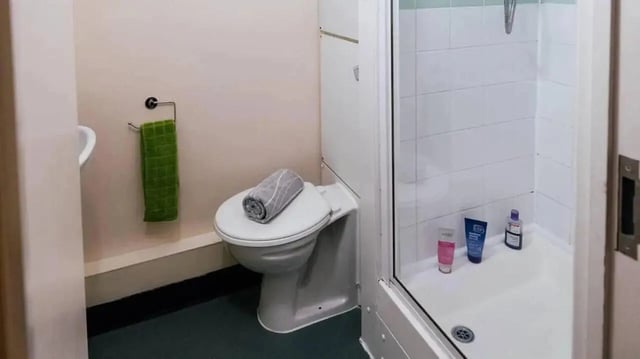 Toilet sink green towel shower enclosure bathroom at Moor Lane Halls in Preston Student Accommodation