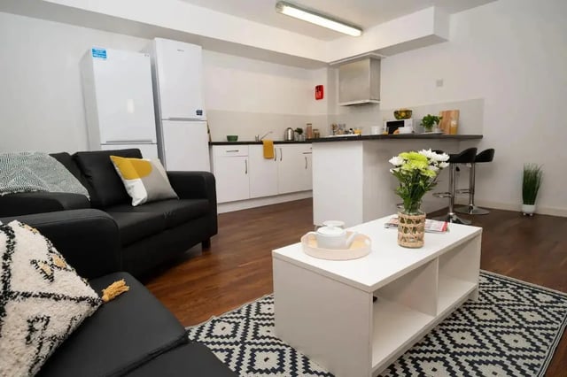 Black sofa white coffee table kitchen living room at Moor Lane Halls in Preston Student Accommodation