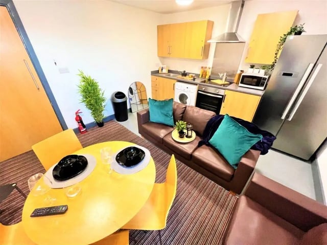 Brown sofa dining table and kitchen living room at Parklane House in Sunderland Student Accommodation