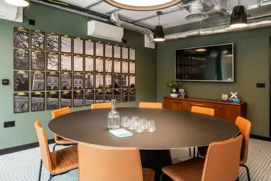 Round table with chairs wall art and television meeting room at Luna Hatfield in Hatfield Student Accommodation