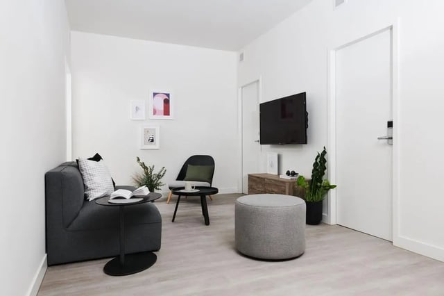 Sofa chair ottoman television artwork living room at Scape Cornell Place in Melbourne Student Accommodation