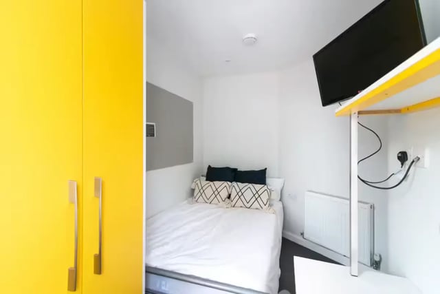Yellow wardrobe bed pillows radiator and TV bedroom at 123 Leek Road in Stoke-On-Trent Student Accommodation