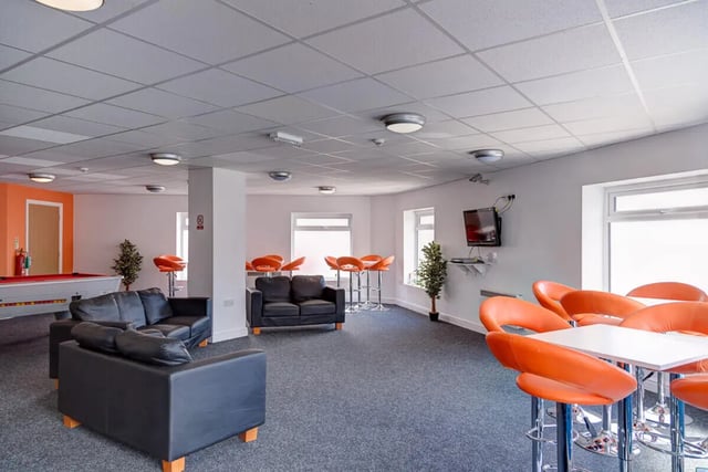Black sofas pool table orange bar stools living room at Dunn House in Sunderland Student Accommodation