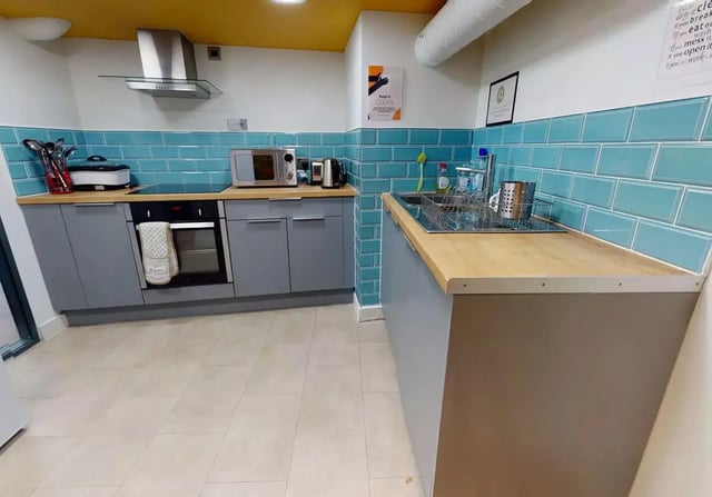 Modern kitchen with grey cabinets and aqua tiles kitchen at iQ Bristol in Bristol Student Accommodation