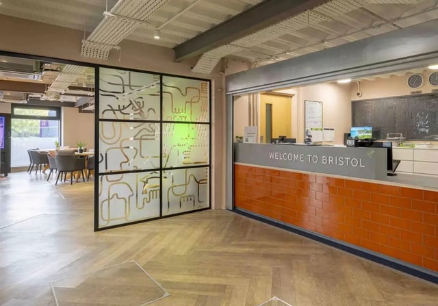 Reception desk with welcome sign and seating area at iQ Bristol in Bristol Student Accommodation