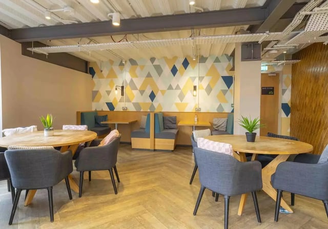 Geometric wallpaper booths tables chairs living room at iQ Bristol in Bristol Student Accommodation