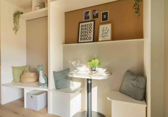 Table and benches with pillows and decor dining area at iQ Bristol in Bristol Student Accommodation