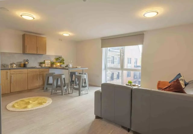 Kitchen area with bar stools and sofa living room at iQ Leeds in Leeds Student Accommodation