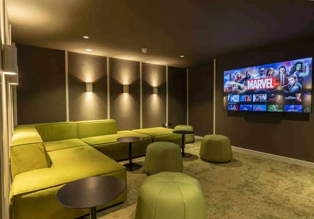 Modern cinema room with green sectional sofa and television at iQ Leeds in Leeds Student Accommodation