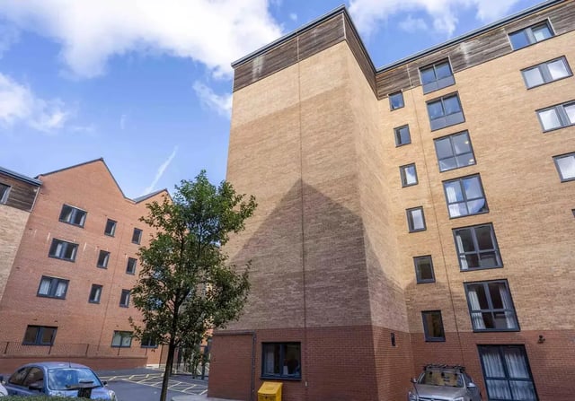 Brick building with windows trees cars exterior at iQ Leeds in Leeds Student Accommodation