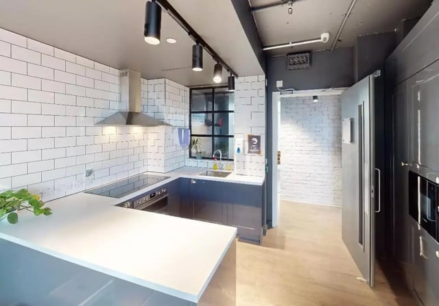 Modern kitchen with white tiled backsplash and grey counters Kitchen at iQ Shoreditch in London Student Accommodation