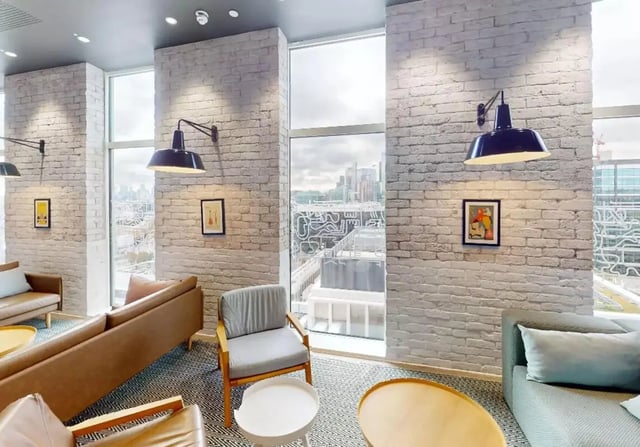 Comfortable sofas armchairs and coffee tables living area at iQ Shoreditch in London Student Accommodation