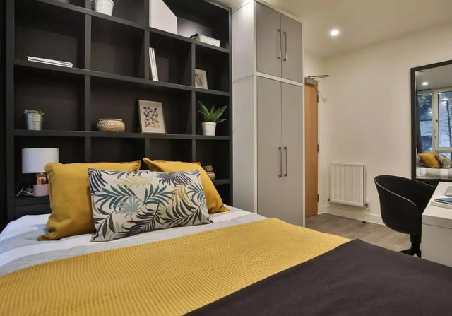 Bed with pillows shelves and cabinets bedroom at iQ Shoreditch in London Student Accommodation