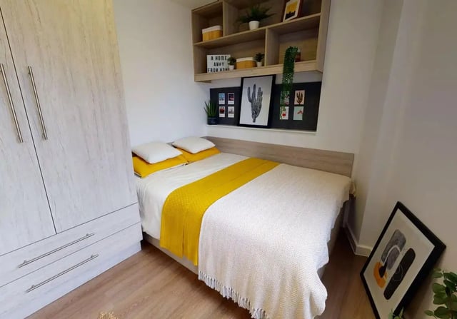 Bed with yellow throw and wardrobe bedroom at iQ Kingston in Kingston Upon Thames Student Accommodation