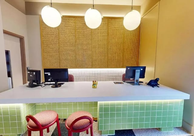 Reception desk with computers and stools exterior at iQ Hoxton in London Student Accommodation