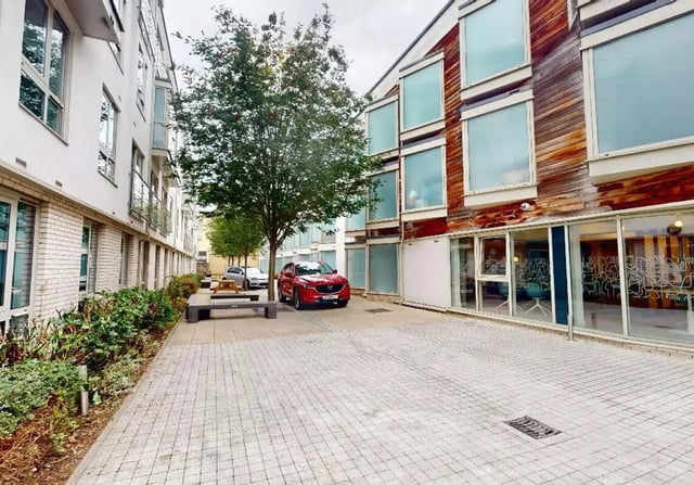 Courtyard with cars benches and buildings Exterior at iQ Hoxton in London Student Accommodation